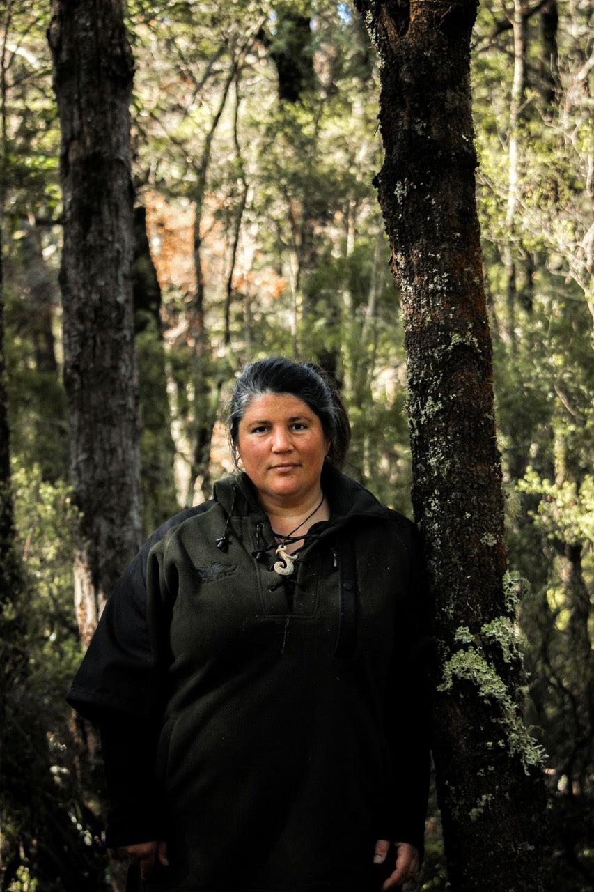 Person standing in a forest with trees and greenery in the background, Huntress wines
