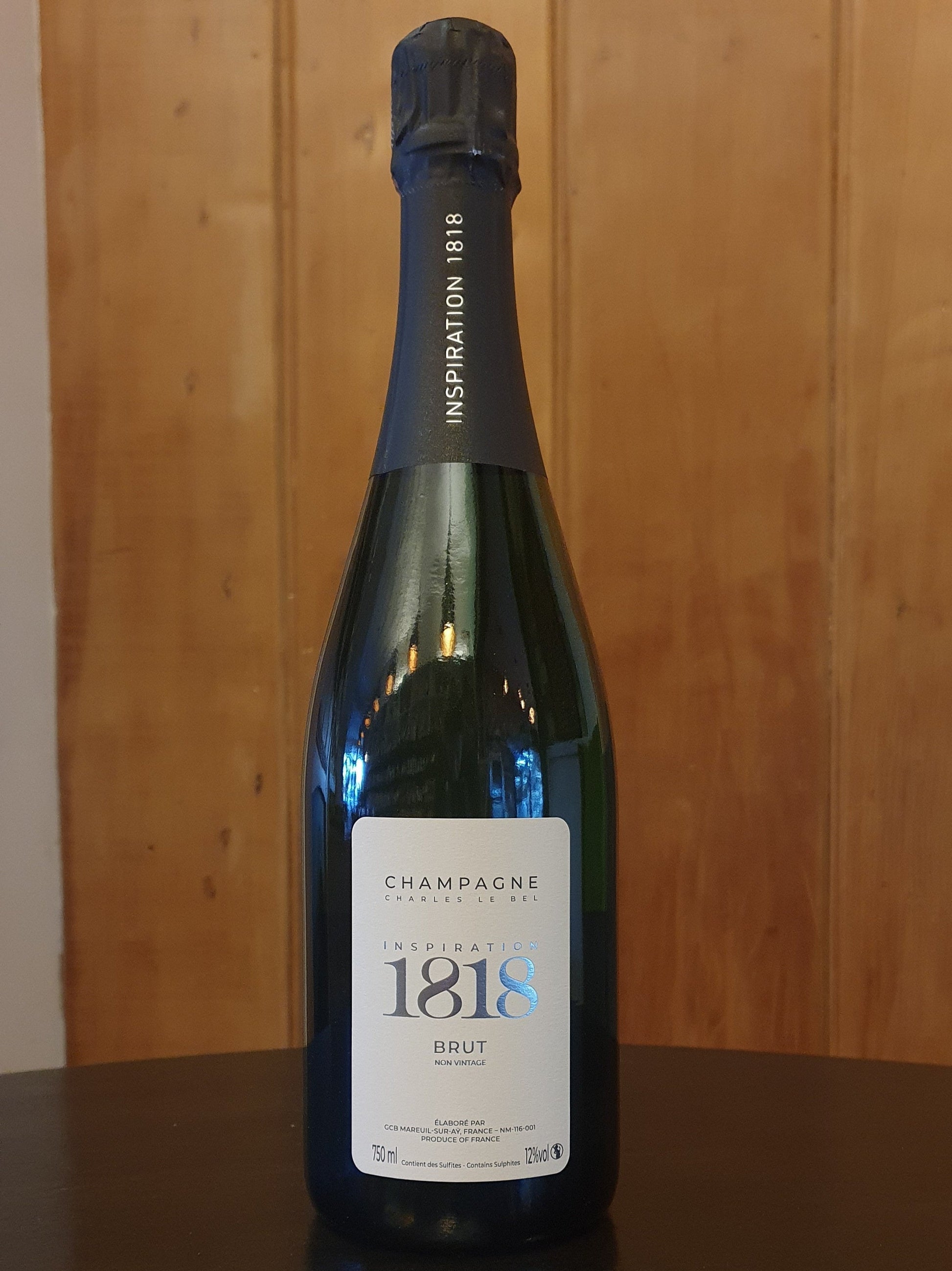 Bottle of 1818 champagne on a wooden surface