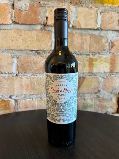Wine bottle with a detailed floral green label on a textured surface