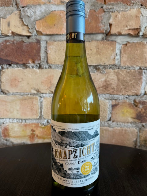 Wine bottle with a label showing the mountains of Stellenbosch and text saying Kaapzicht against a brick wall background