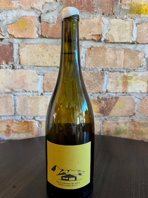 Wine bottle with a yellow label on a brick surface