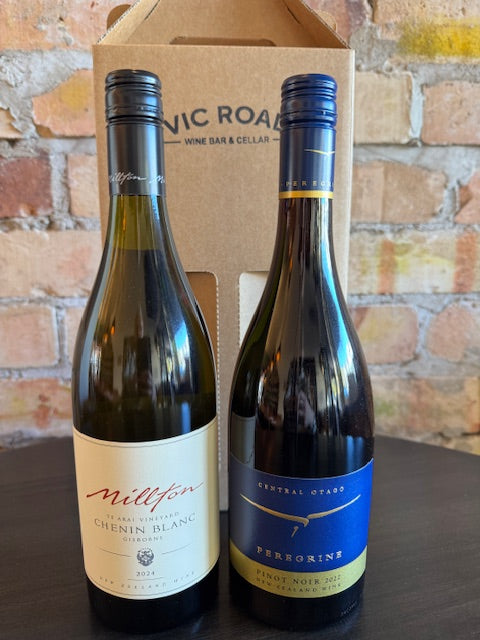 Two wine bottles on a wooden box with a brick wall background