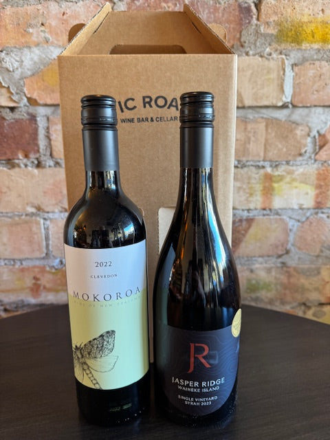 Two wine bottles on a wooden stand with a brick wall background