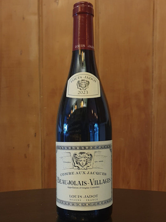 Bottle of Louis Jadot Beaujolais-Villages wine against a wooden background