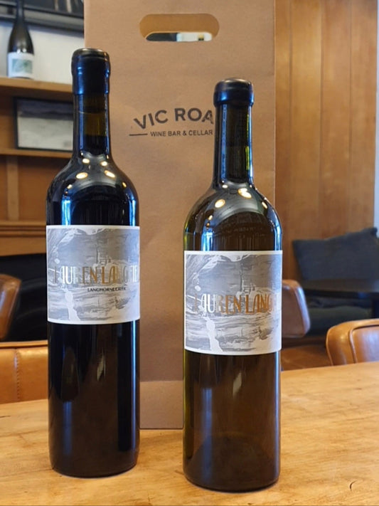 Two bottles of Lauren Langfield wine on a table with a wooden box labeled 'Vic Road Wine Bar' in the background.
